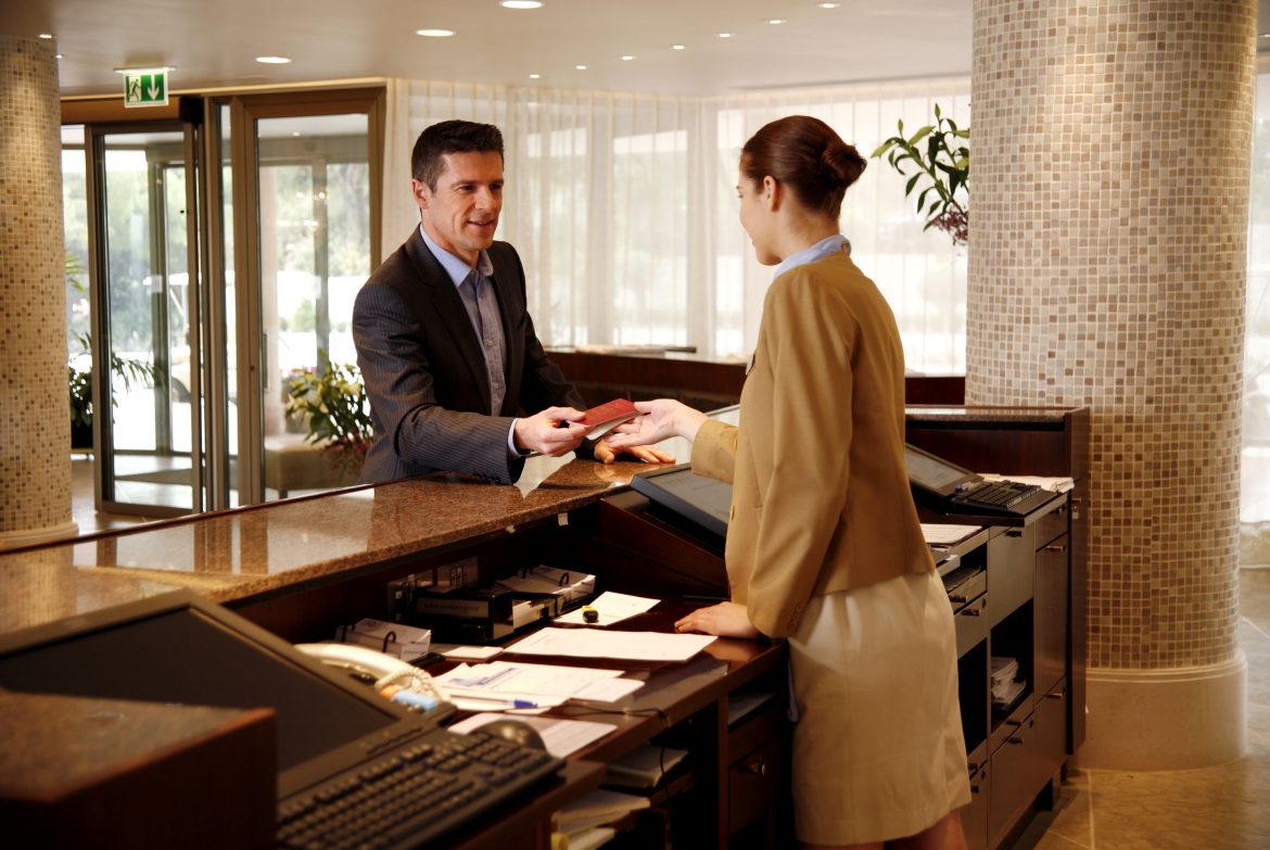 Guest checking in at the hotel reception for longer stay STAAH Blog