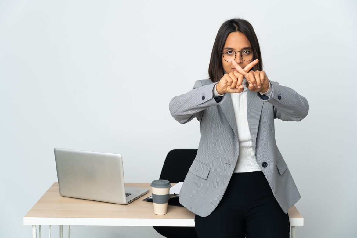 young latin business woman working office isolated white background making stop gesture with her hand stop act